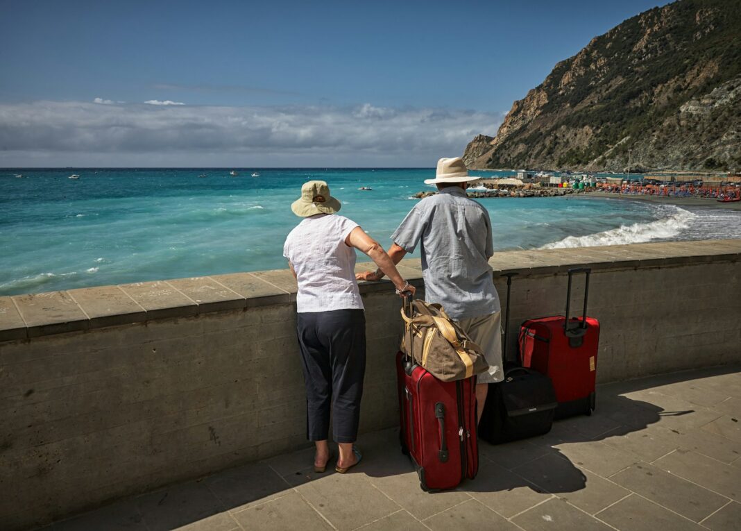 man and woman standing beside concrete seawall looking at beach