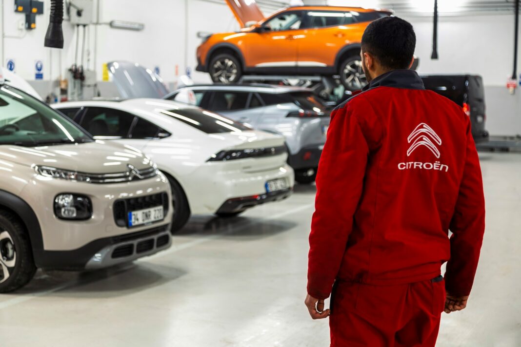 A man standing in a garage looking at cars